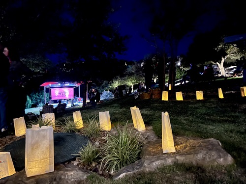 Stage set up in distance with luminaries lighting path in the dark.